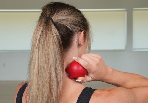 Knuklball being applied to neck muscles by user for pain relief